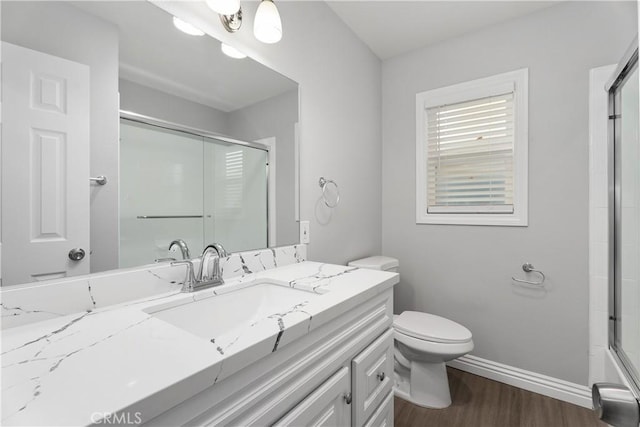 1440 E Abila St, Carson, CA 90745 - full bath featuring wood finished floors, a shower with door, vanity, baseboards, and toilet