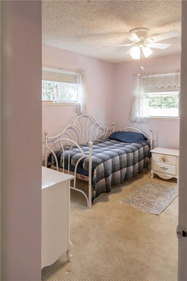 13372 Newhope St, Garden Grove, CA 92843 - bedroom featuring light carpet, multiple windows, a textured ceiling, and a ceiling fan