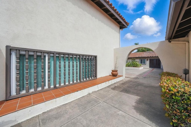 12234 Rancho Bernardo Rd Unit A, Rancho Bernardo San Diego, CA 92128 - view of property exterior with stucco siding, a tiled roof, and a patio