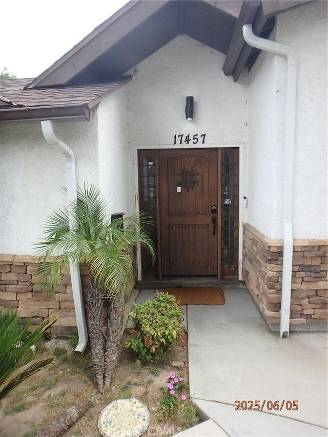 17457 Covello St, Van Nuys, CA 91406 - property entrance with stucco siding, stone siding, and roof with shingles
