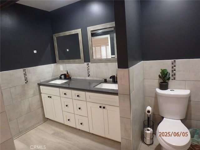 17457 Covello St, Van Nuys, CA 91406 - full bathroom with tile walls, double vanity, toilet, wainscoting, and wood finished floors