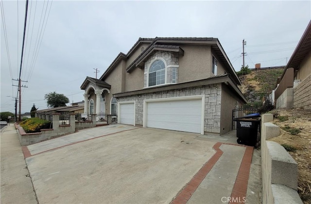 1389 Hillside St, Monterey Park, CA 91754 - view of front facade featuring stucco siding, stone siding, an attached garage, and concrete driveway