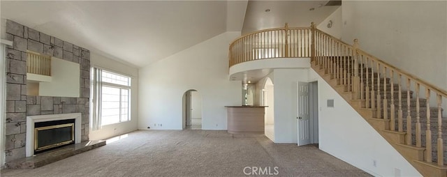 1389 Hillside St, Monterey Park, CA 91754 - unfurnished living room featuring high vaulted ceiling, carpet flooring, arched walkways, a large fireplace, and stairs