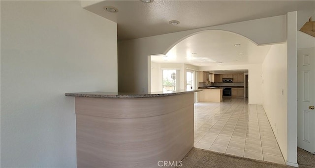 1389 Hillside St, Monterey Park, CA 91754 - corridor featuring light tile patterned floors, arched walkways, and light carpet