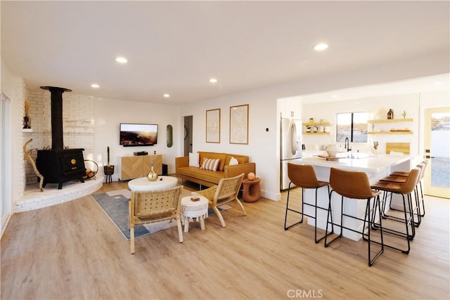 63326 Sunny Sands Dr, Joshua Tree, CA 92252 - living room with light wood-style floors, a wood stove, recessed lighting, and baseboards