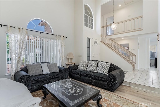 25213 Via Las Lomas, Murrieta, CA 92562 - living room featuring stairway, a towering ceiling, and wood finished floors