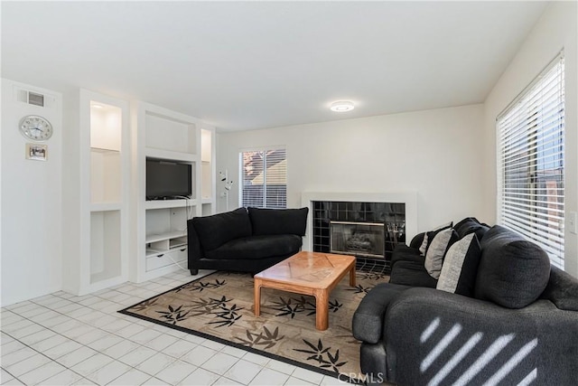 25213 Via Las Lomas, Murrieta, CA 92562 - living room with built in features, a tiled fireplace, and tile patterned flooring