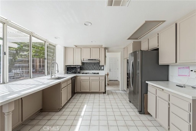 25213 Via Las Lomas, Murrieta, CA 92562 - kitchen with under cabinet range hood, appliances with stainless steel finishes, backsplash, and light countertops