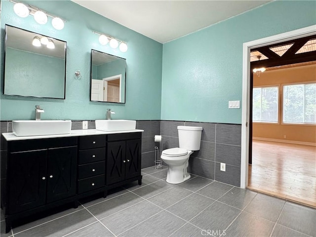 8 Geneva Ln, Chico, CA 95926 - bathroom featuring tile walls, tile patterned flooring, double vanity, toilet, and wainscoting
