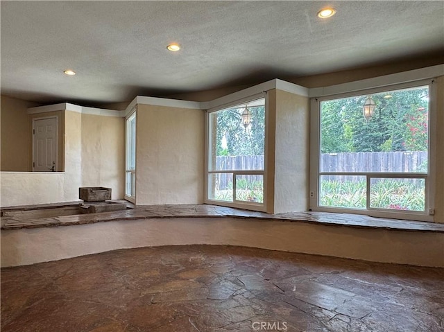 8 Geneva Ln, Chico, CA 95926 - empty room featuring a textured ceiling, stone finish flooring, plenty of natural light, and recessed lighting