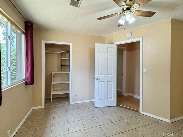 8 Geneva Ln, Chico, CA 95926 - unfurnished bedroom with a textured ceiling, multiple windows, light tile patterned floors, baseboards, and a closet