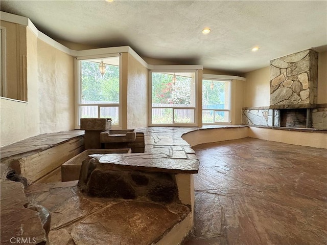 8 Geneva Ln, Chico, CA 95926 - living room with stone finish flooring, plenty of natural light, a fireplace, a textured ceiling, and recessed lighting