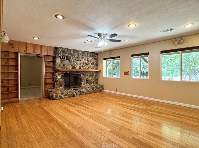 8 Geneva Ln, Chico, CA 95926 - unfurnished living room featuring light wood finished floors, a textured ceiling, ceiling fan, baseboards, and a fireplace