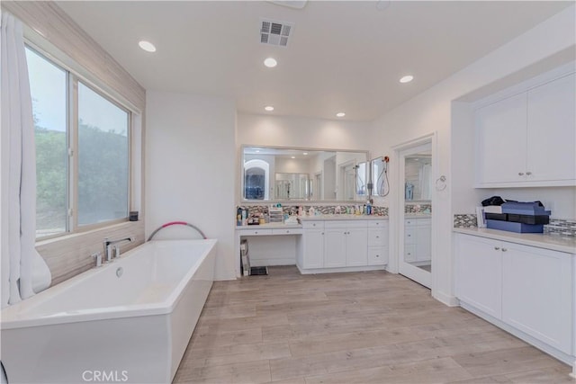 1189 Canyon Glen Rd, Chino Hills, CA 91709 - bathroom with a freestanding tub, vanity, wood finished floors, recessed lighting, and decorative backsplash