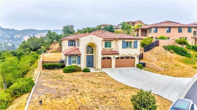 1189 Canyon Glen Rd, Chino Hills, CA 91709 - mediterranean / spanish home featuring an attached garage, a tiled roof, driveway, stucco siding, and a mountain view