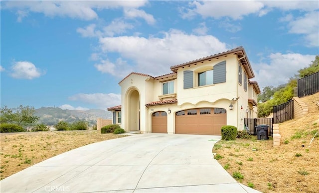 1189 Canyon Glen Rd, Chino Hills, CA 91709 - mediterranean / spanish-style house featuring a garage, driveway, a tiled roof, stucco siding, and a mountain view