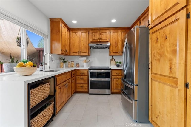 3021 S Sycamore St Unit D, Santa Ana, CA 92707 - kitchen with appliances with stainless steel finishes, under cabinet range hood, brown cabinets, light countertops, and recessed lighting
