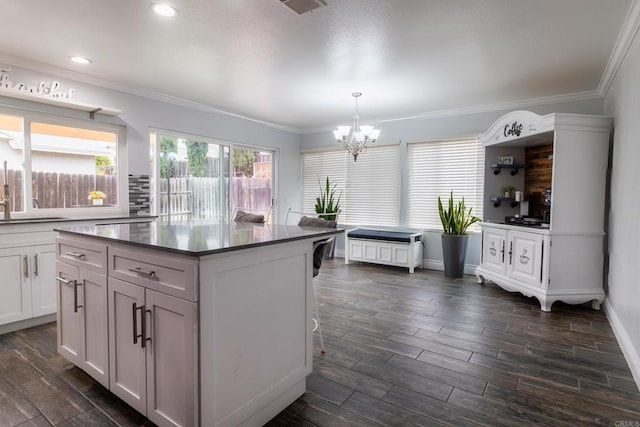 1242 Pleasant Hill St, Escondido, CA 92026 - kitchen with a chandelier, ornamental molding, dark wood finished floors, a kitchen island, and white cabinets