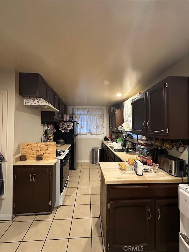 907 E Ghent St, Azusa, CA 91702 - kitchen with light countertops, light tile patterned floors, freestanding refrigerator, and gas range gas stove