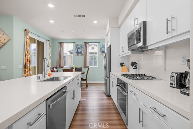 8254 Traveller St, Chino, CA 91708 - kitchen with stainless steel appliances, a sink, recessed lighting, light countertops, and dark wood-type flooring