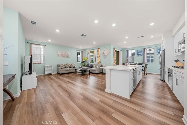 8254 Traveller St, Chino, CA 91708 - kitchen featuring stainless steel appliances, white cabinets, light countertops, a sink, and recessed lighting