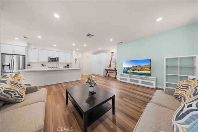 8254 Traveller St, Chino, CA 91708 - living room with recessed lighting, light wood-style floors, and baseboards