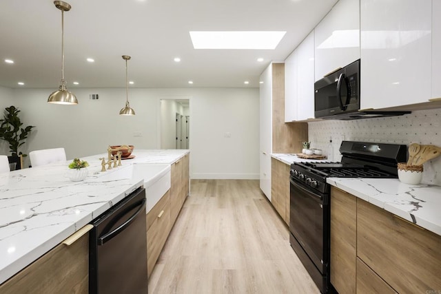 4380 Rolfe Rd, San Diego, CA 92117 - kitchen with black appliances, modern cabinets, a skylight, white cabinets, and light wood-style flooring