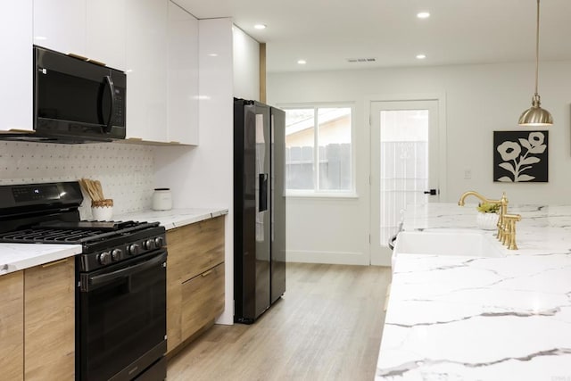 4380 Rolfe Rd, San Diego, CA 92117 - kitchen with black appliances, modern cabinets, light wood-style flooring, light stone countertops, and recessed lighting
