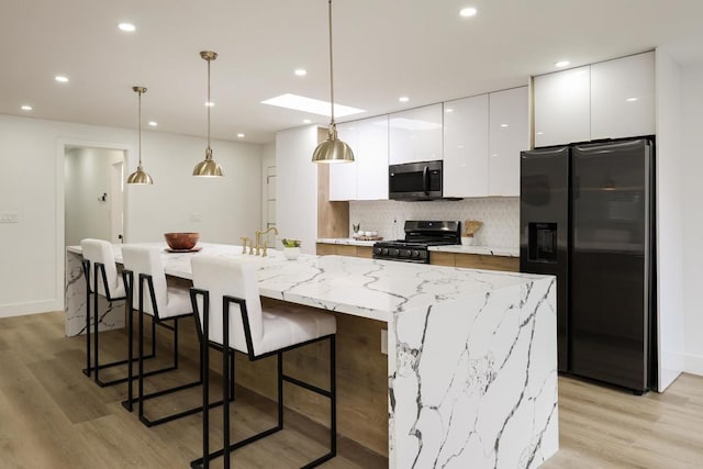 4380 Rolfe Rd, San Diego, CA 92117 - kitchen with appliances with stainless steel finishes, white cabinets, a large island, modern cabinets, and light wood-type flooring