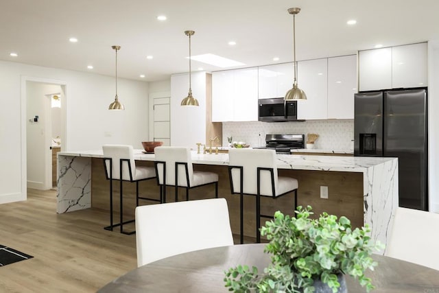 4380 Rolfe Rd, San Diego, CA 92117 - kitchen featuring appliances with stainless steel finishes, white cabinets, a large island with sink, decorative backsplash, and modern cabinets