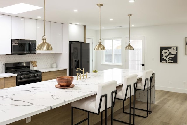 4380 Rolfe Rd, San Diego, CA 92117 - kitchen with stainless steel gas range, black refrigerator with ice dispenser, modern cabinets, white cabinets, and recessed lighting