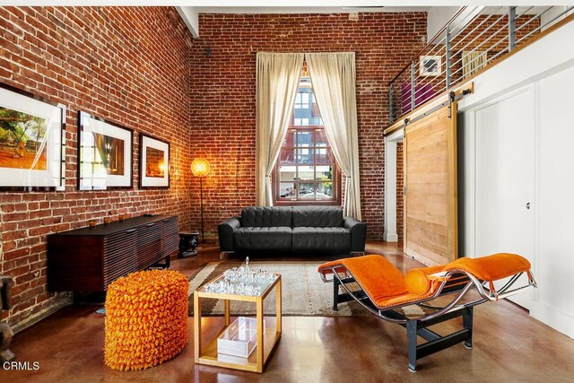 940 E 2nd St Unit 37, Los Angeles, CA 90012 - sitting room featuring brick wall, finished concrete floors, and a barn door