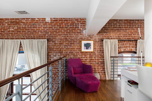 940 E 2nd St Unit 37, Los Angeles, CA 90012 - sitting room featuring brick wall, wood finished floors, and an upstairs landing