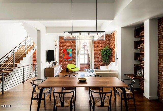 940 E 2nd St Unit 37, Los Angeles, CA 90012 - dining room featuring brick wall, wood finished floors, and stairs