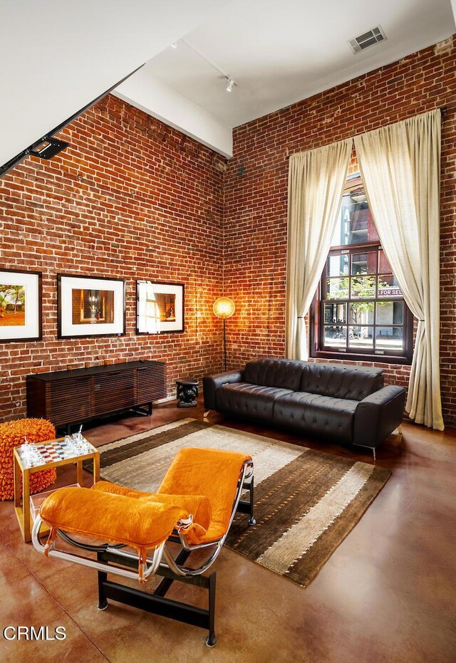940 E 2nd St Unit 37, Los Angeles, CA 90012 - living area featuring brick wall, concrete flooring, and track lighting