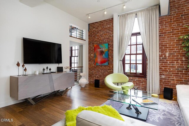 940 E 2nd St Unit 37, Los Angeles, CA 90012 - living room with wood finished floors, brick wall, and track lighting