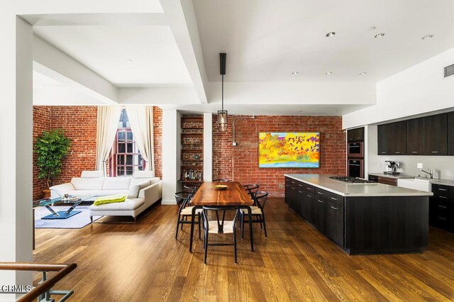 940 E 2nd St Unit 37, Los Angeles, CA 90012 - dining room featuring brick wall and dark wood-style floors