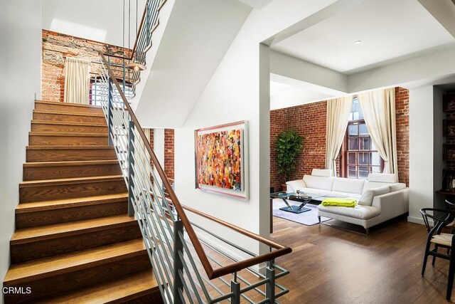 940 E 2nd St Unit 37, Los Angeles, CA 90012 - stairs with brick wall, wood finished floors, and a high ceiling