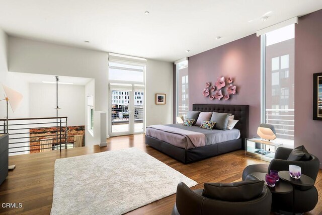 940 E 2nd St Unit 37, Los Angeles, CA 90012 - bedroom featuring multiple windows, wood finished floors, and expansive windows