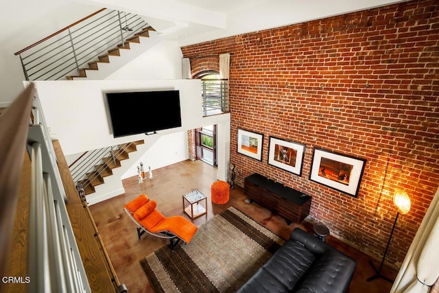 940 E 2nd St Unit 37, Los Angeles, CA 90012 - living room featuring stairs, brick wall, and wood finished floors