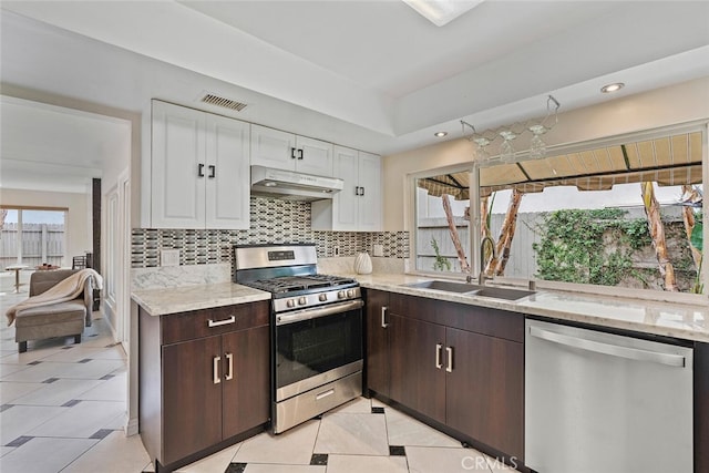 22702 Islamare Ln, Lake Forest, CA 92630 - kitchen with stainless steel appliances, a sink, under cabinet range hood, white cabinetry, and plenty of natural light
