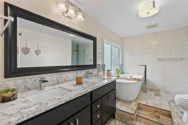 22702 Islamare Ln, Lake Forest, CA 92630 - full bathroom featuring a soaking tub, double vanity, tile walls, tiled shower, and toilet