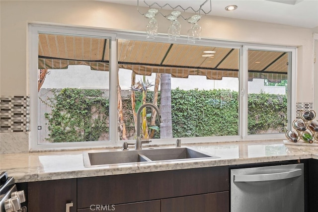 22702 Islamare Ln, Lake Forest, CA 92630 - kitchen featuring stainless steel appliances, dark brown cabinetry, a sink, light stone counters, and decorative backsplash