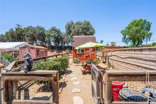 1390 Corona Ave, Norco, CA 92860 - fenced backyard featuring a storage unit and a garden