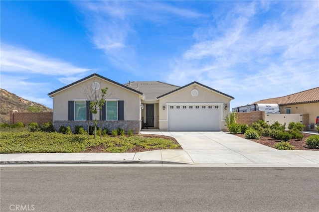 24909 Miners View Ln, Moreno Valley, CA 92557 - single story home featuring stucco siding, an attached garage, driveway, and brick siding