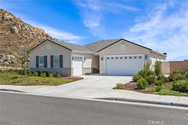 24909 Miners View Ln, Moreno Valley, CA 92557 - ranch-style home with a garage, stucco siding, concrete driveway, brick siding, and a tiled roof