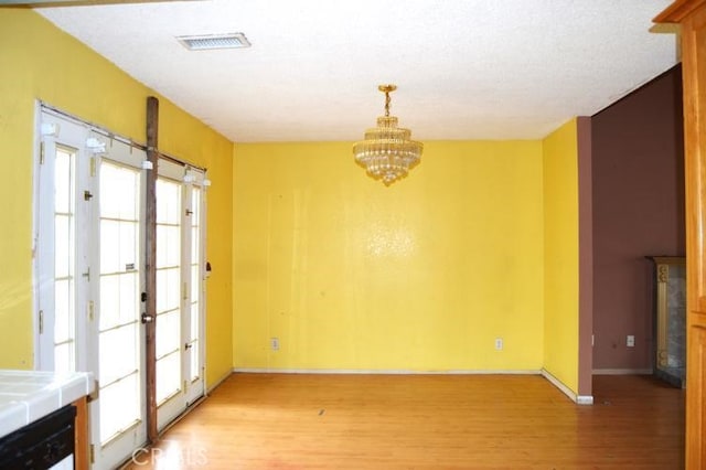 12077 Swegles Ln, Moreno Valley, CA 92557 - unfurnished dining area featuring light wood-style flooring, a chandelier, and baseboards