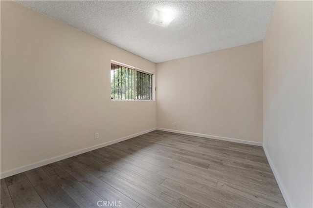 4820 Eagle St, Los Angeles, CA 90022 - empty room with a textured ceiling, wood finished floors, and baseboards