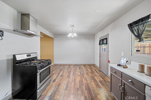 5150 N Berkeley Ave, San Bernardino, CA 92407 - kitchen featuring stainless steel gas stove, wall chimney range hood, hardwood / wood-style floors, light countertops, and a chandelier