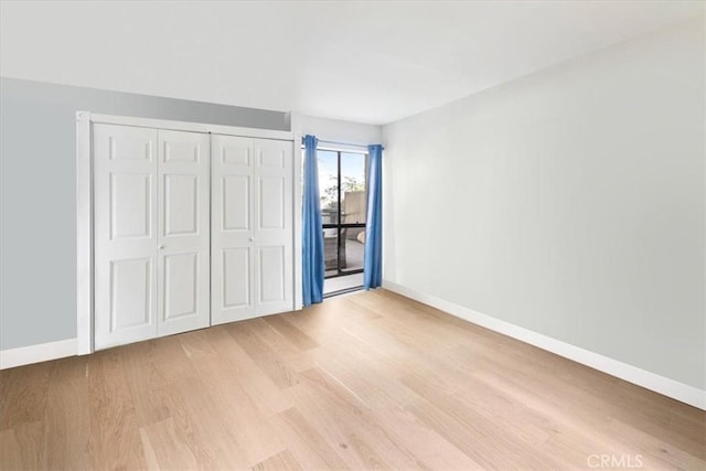 898 Temple Unit 125, Los Angeles, CA 90042 - unfurnished bedroom featuring light wood-style flooring, access to outside, baseboards, and a closet
